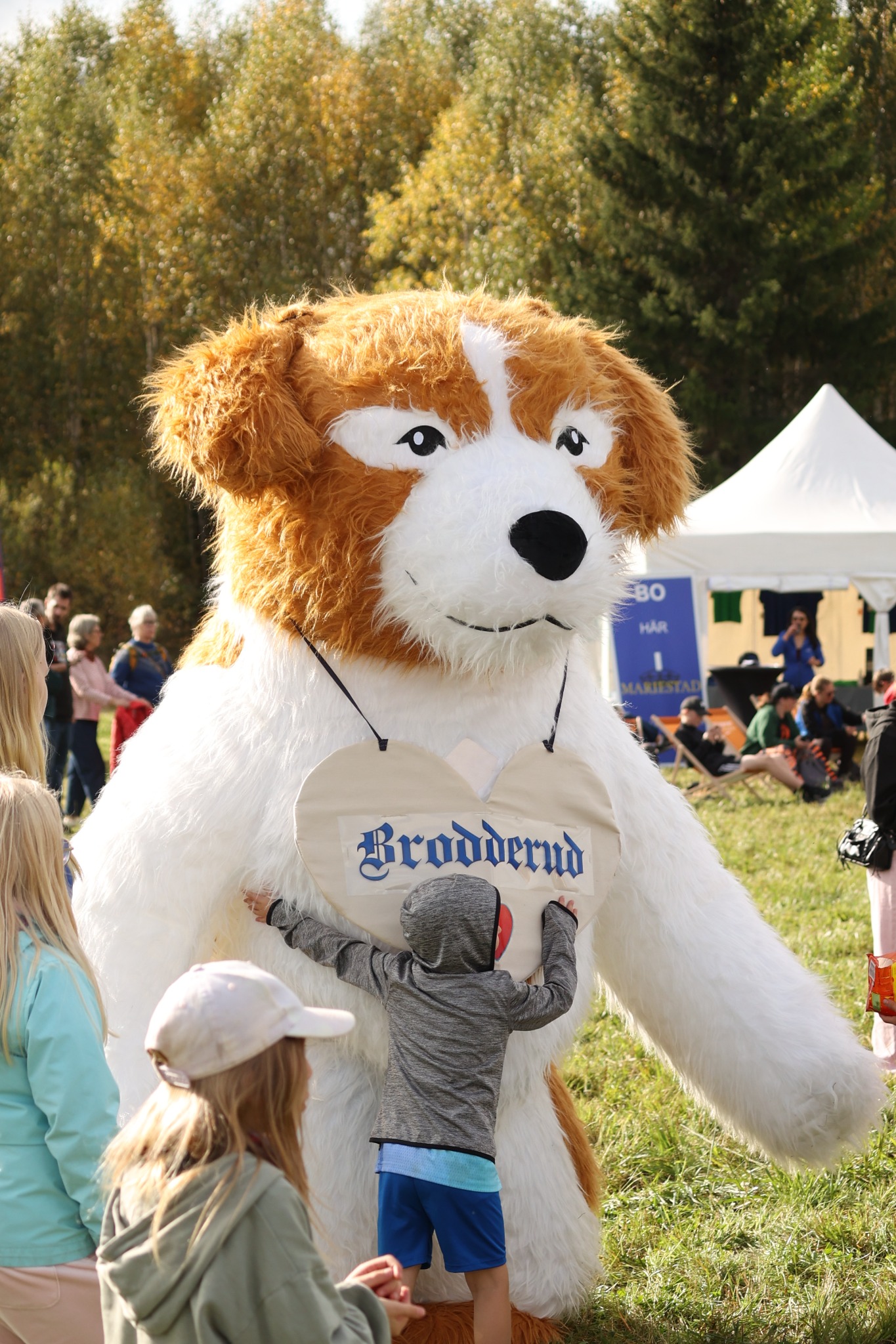 Brodderuds hundmaskot Hasse med hjärtskylt får en kram på E20-loppet