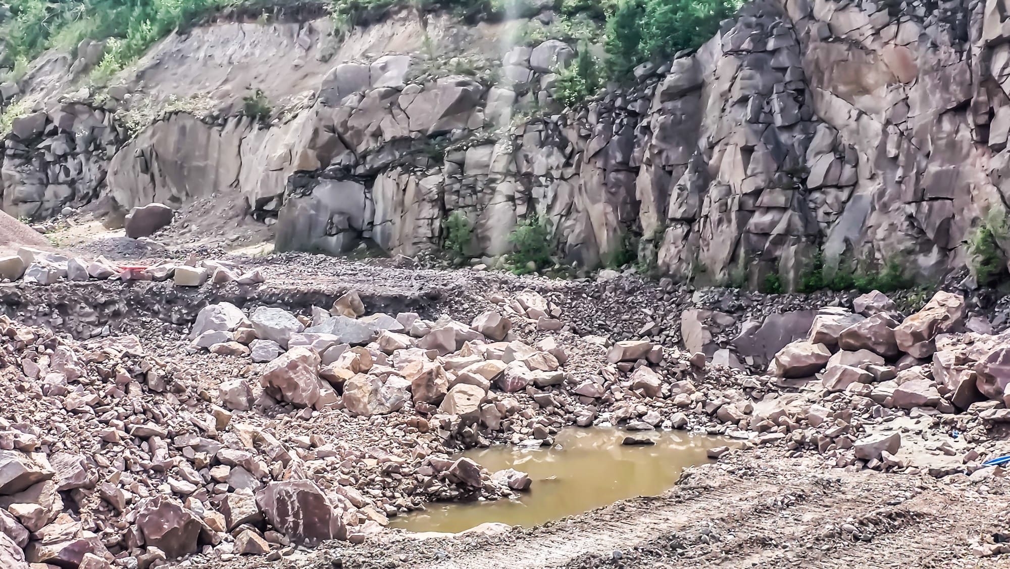 Brutet bergmaterial och bergvägg i Brodderuds bergtäkt