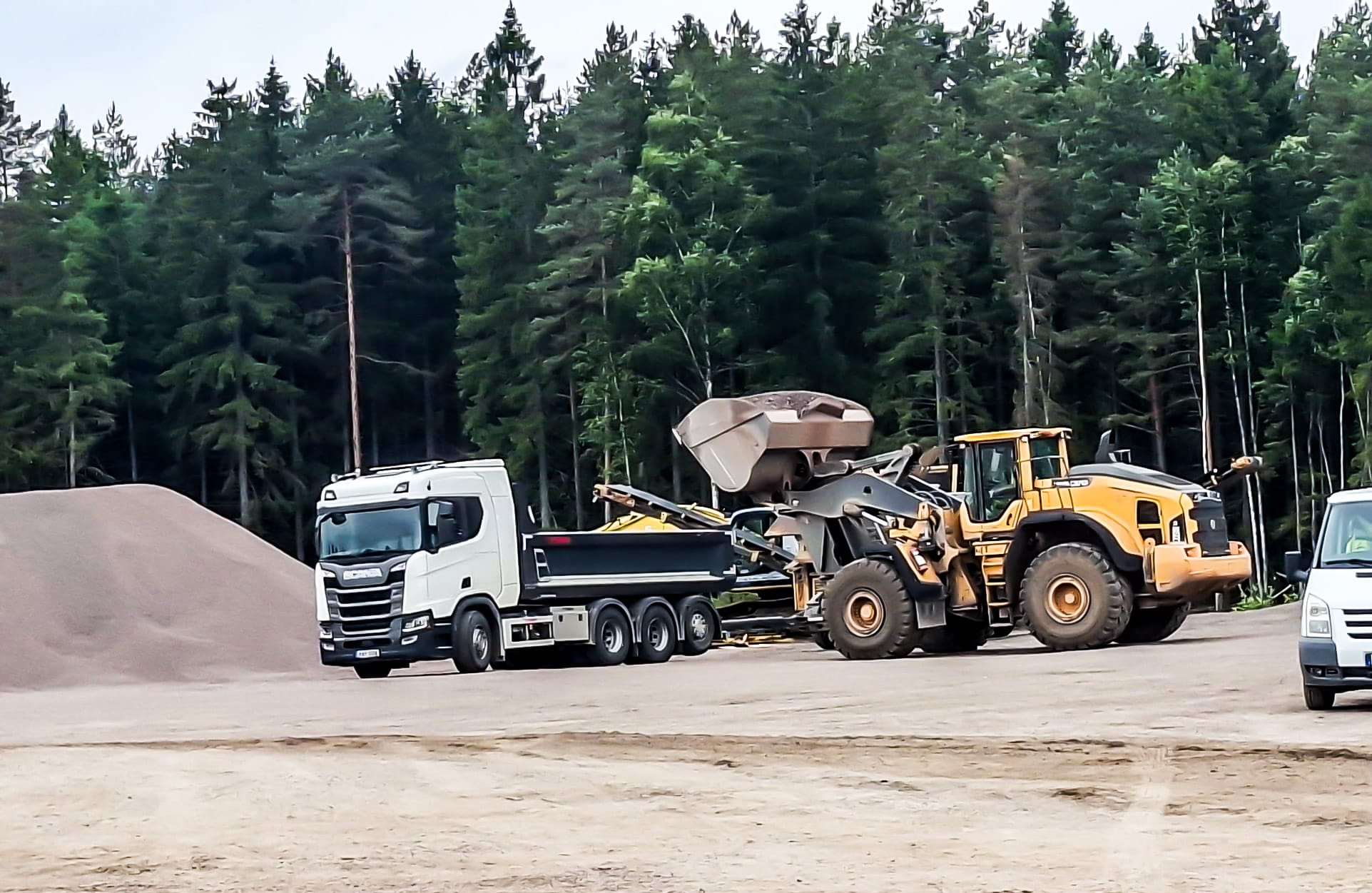 Hjullastare lastar bergmaterial på en lastbil i Brodderuds bergtäkt